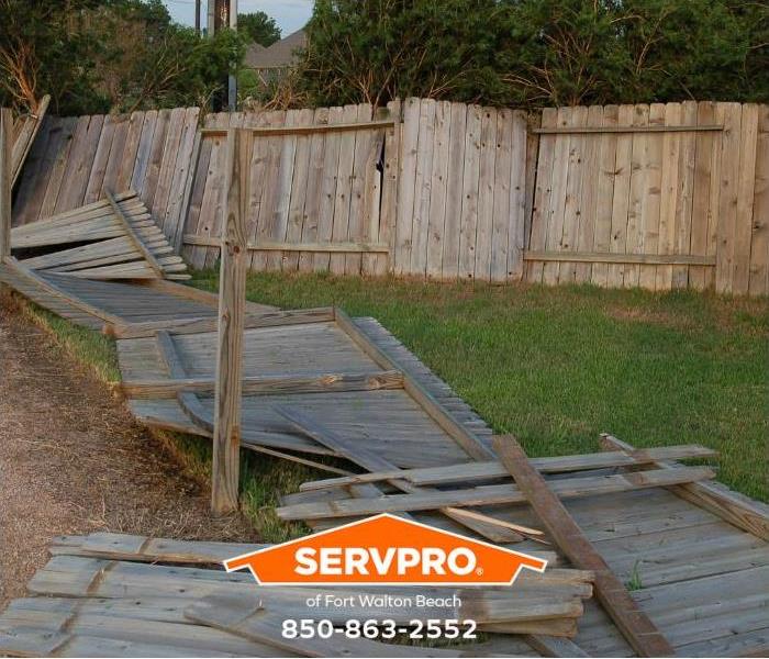 A fence has blown over in a backyard.